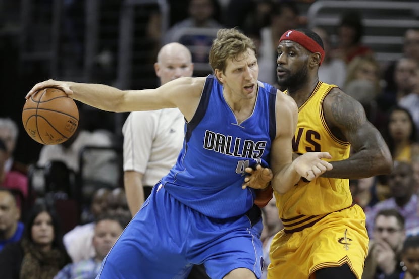 Dallas Mavericks' Dirk Nowitzki, from Germany, backs in on Cleveland Cavaliers' LeBron...