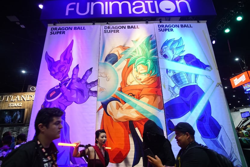 Attendees walk in front of the Funimation booth at the San Diego Convention Center during...