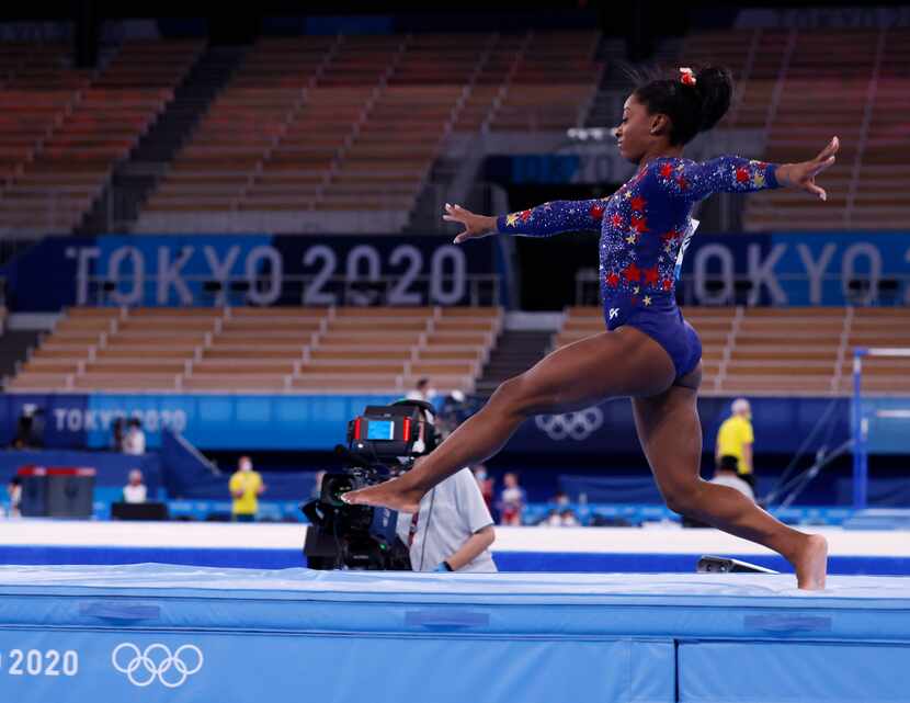 USA’s Simone Biles takes a few steps upon landing while competing on the balance beam in a...