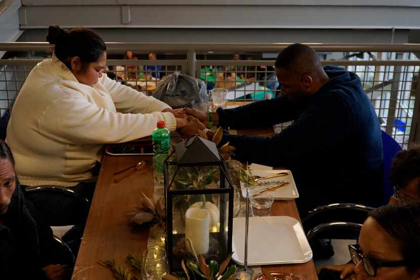 Maria Salazar and Rob Wyley prayed before Thanksgiving dinner at Our Calling Homeless...