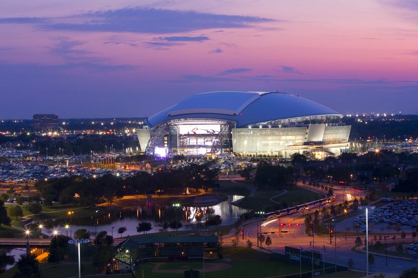The sun sets behind AT&T Stadium, formerly named Cowboys Stadium, on Sunday, September 20,...