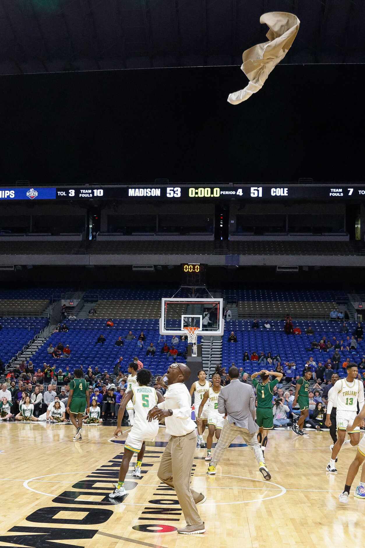 Madison head coach Damien Mobley watches his suit jacket fly through the air after tossing...