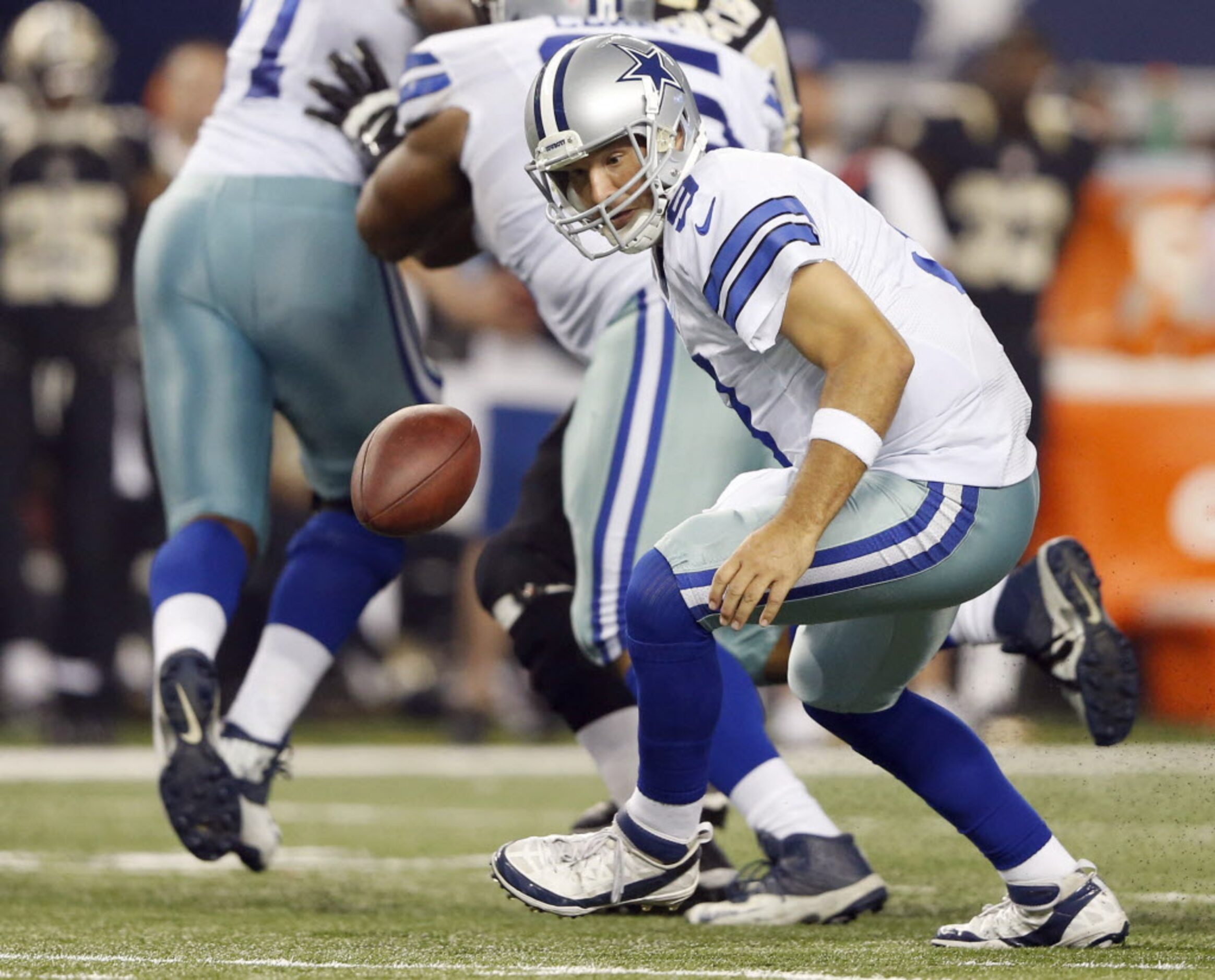 Dallas Cowboys quarterback Tony Romo (9) chases after a botched snap in a game against the...