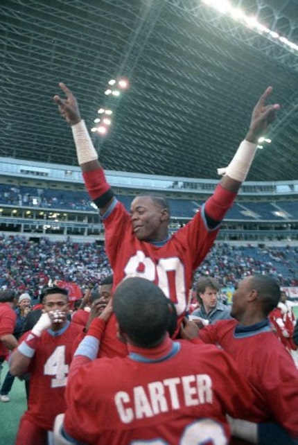 Derric Evans celebrates with his teammates after Carter won the 5A state championship at...