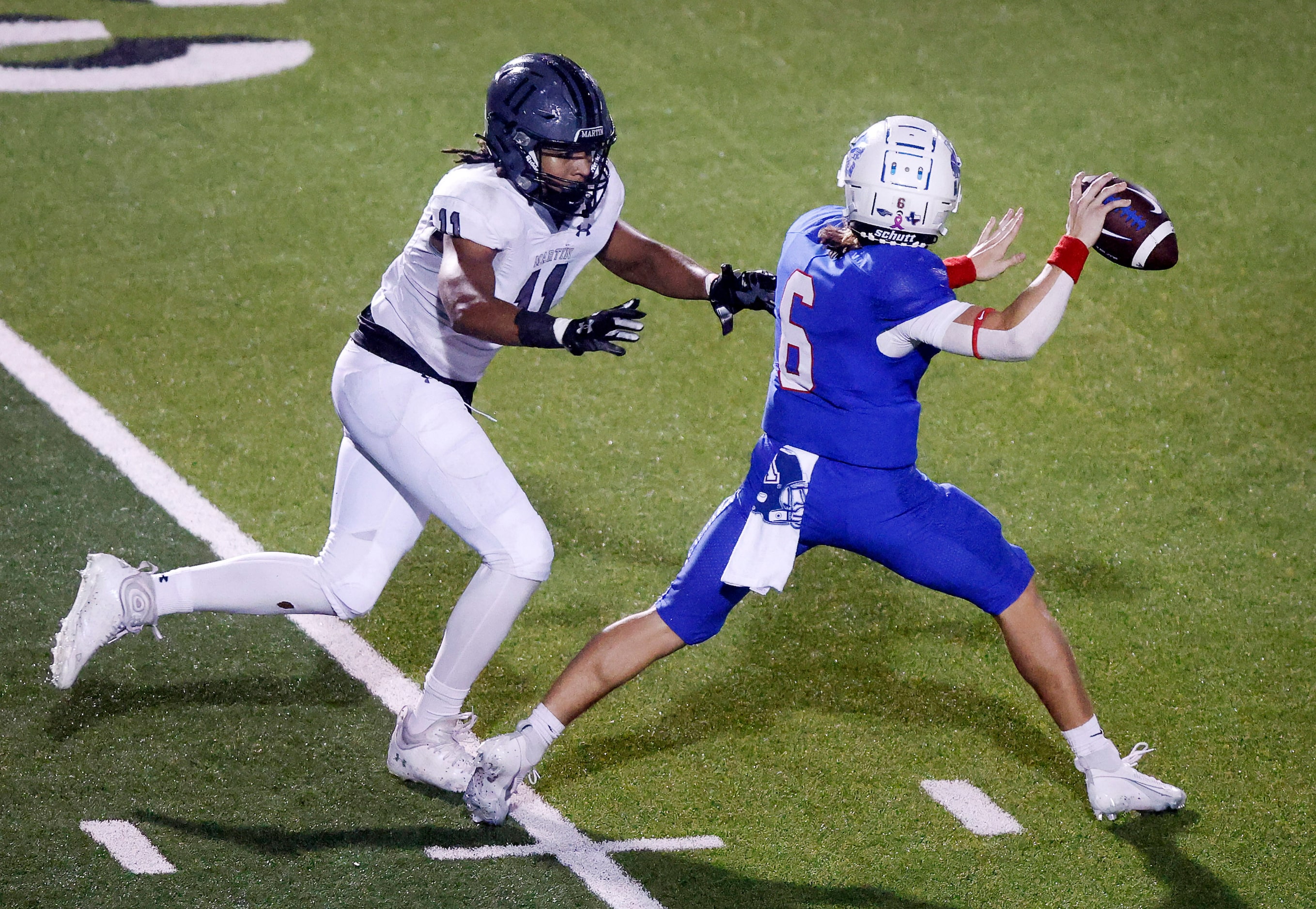 Arlington Martin defensive lineman Ryan Reed (11) forces Allen quarterback Dylan Chapman to...