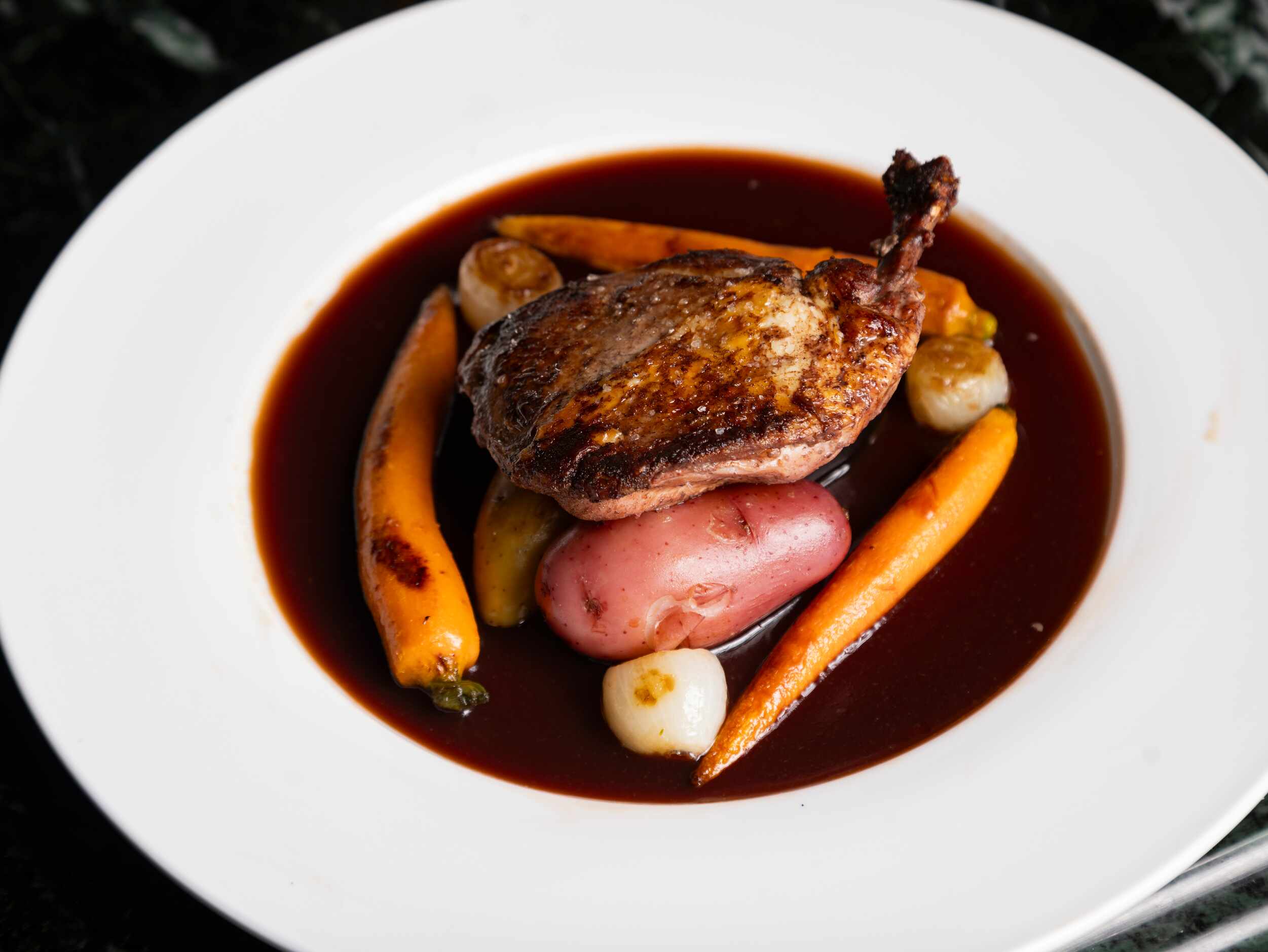 Coq au vin rouge at St. Martin's Wine Bistro is made with bone-in chicken breast, pearl...
