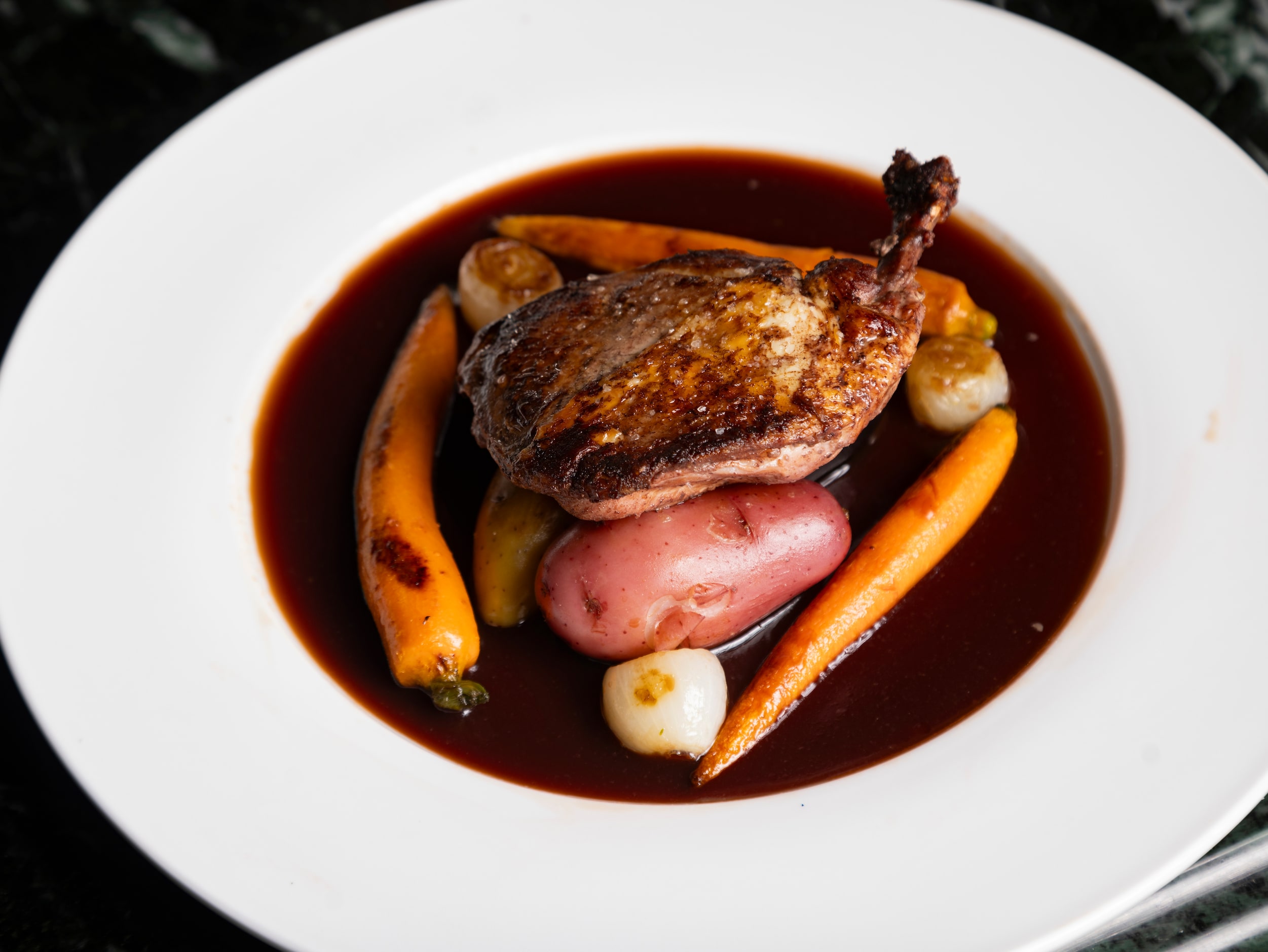 Coq au vin rouge at St. Martin's Wine Bistro is made with bone-in chicken breast, pearl...