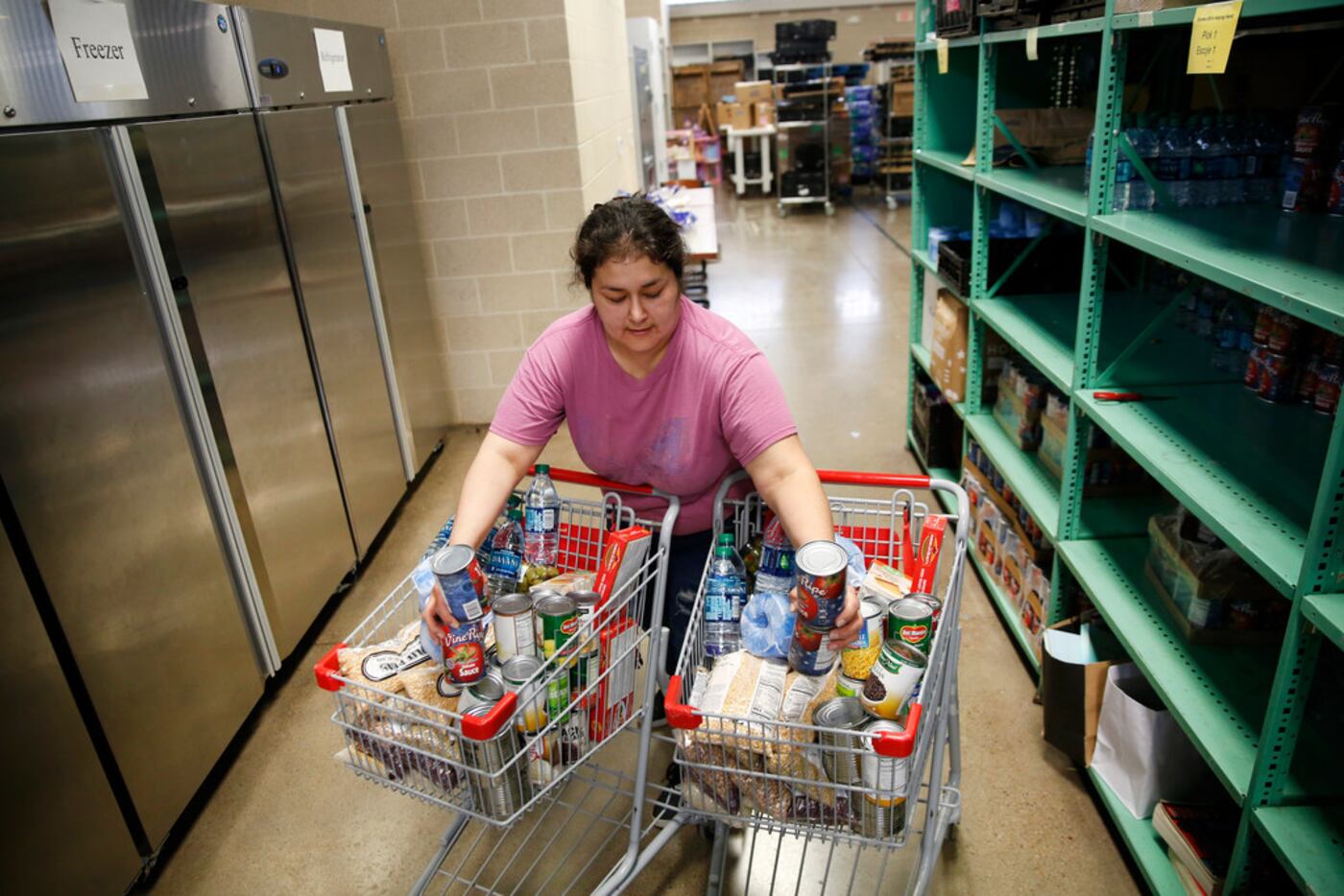 Volunteer Sulin Martinez helps pack meals for deliver to the elderly and homebound at...