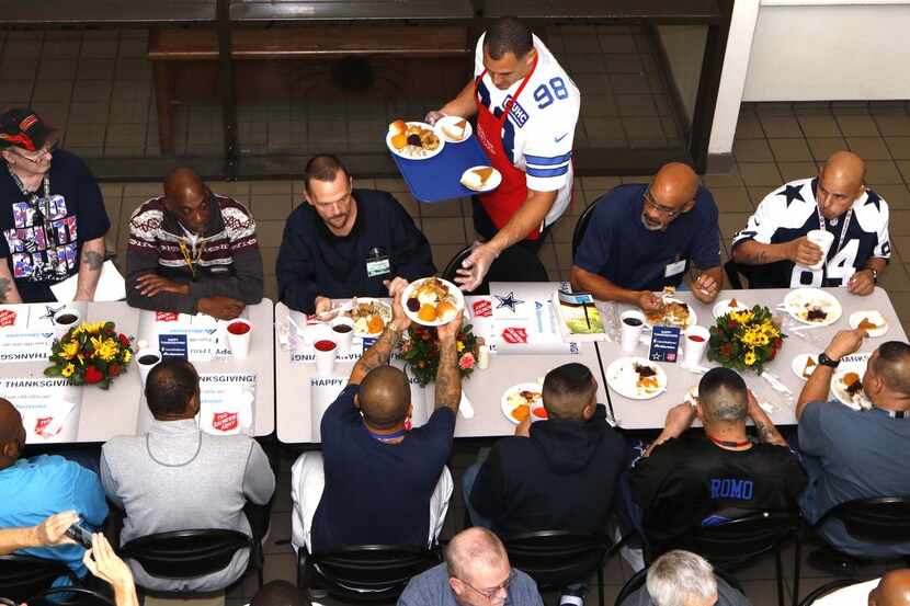 El jugador de los Cowboys Tyrone Crawford sirve comida durante una cena de Acción de Gracias...
