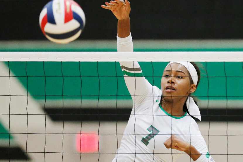 Southlake Carroll junior Asjia O'Neal spikes the ball during a volleyball game against...