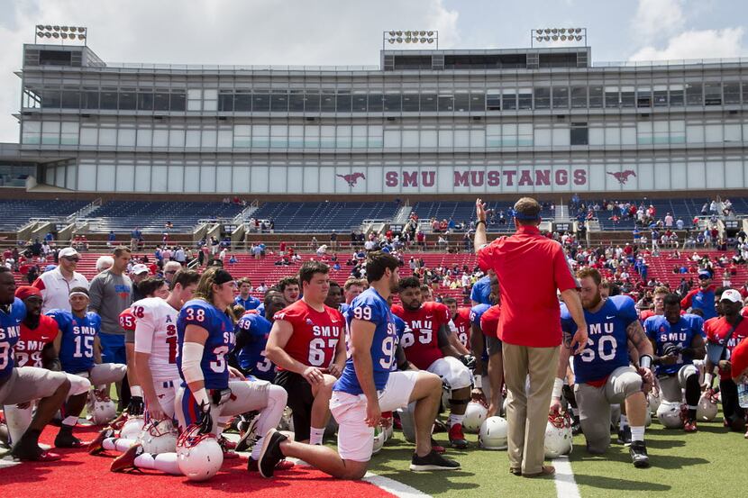 SMU players gather around SMU head coach Chad Morris after the team's spring football game...