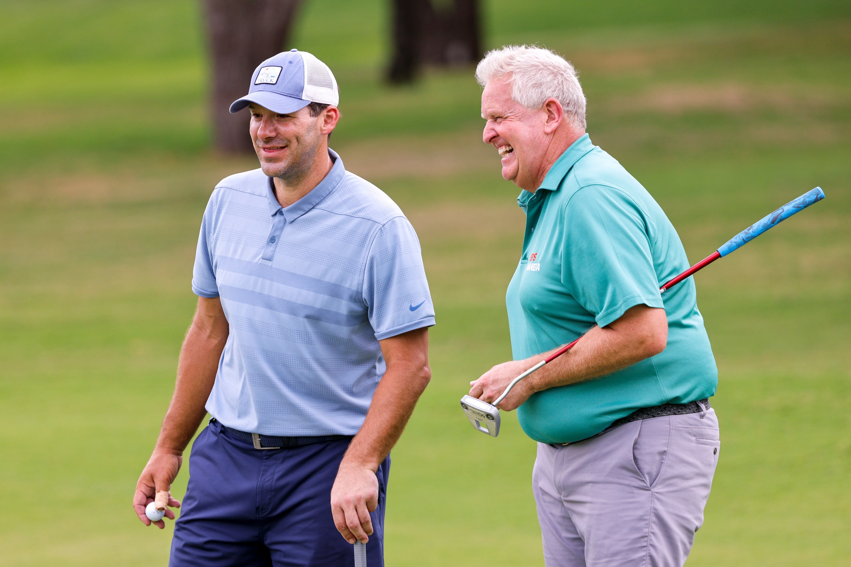 Former Dallas Cowboys quarterback Tony Romo laughs with professional golfer Colin...