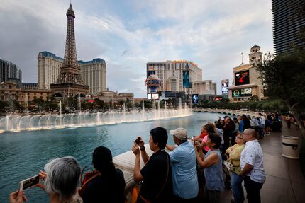 Tourists watch the dancing water feature at Bellagio Fountain along the Las Vegas strip...