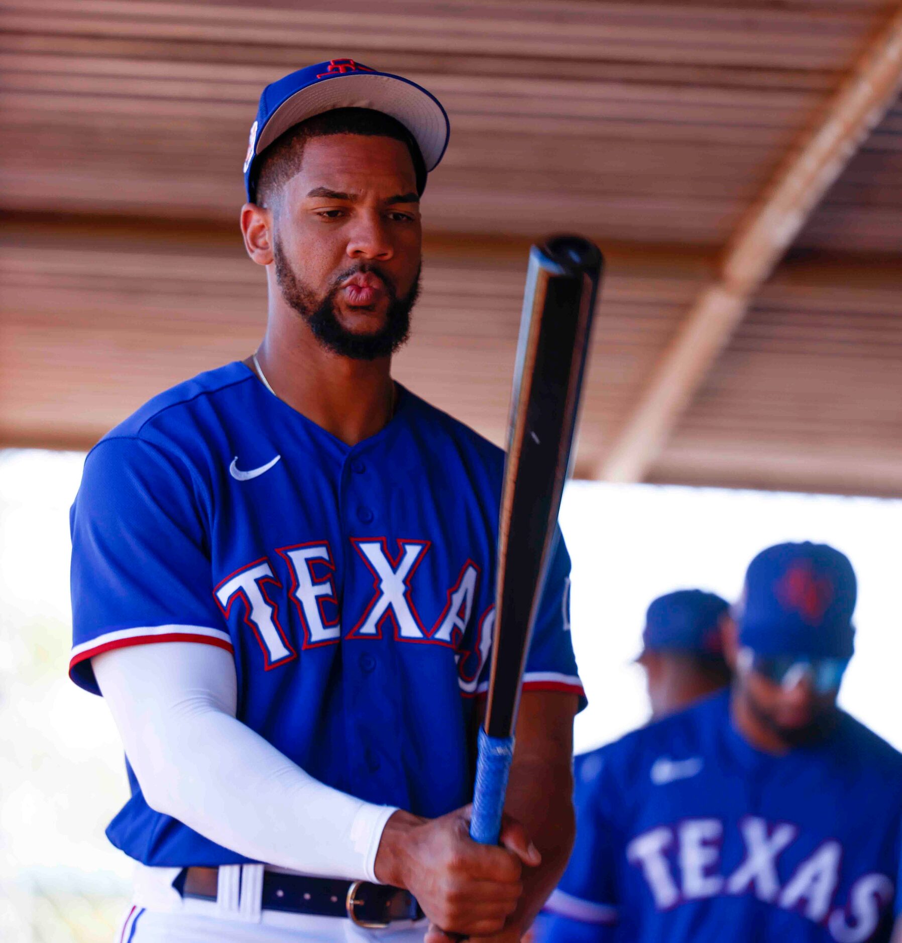 Texas Rangers outfielder Leody Taveras checks out a bat during a drill at spring training...