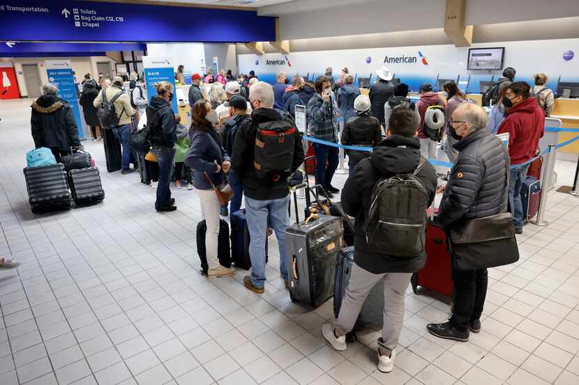 Passengers check in for flights at DFW International Airport’s Terminal C on Friday....