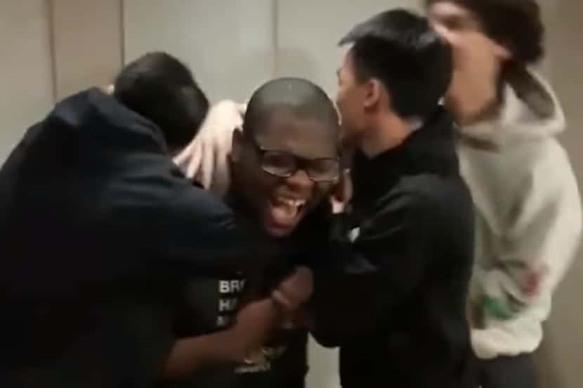 Lamar High School senior Micheal Brown is hugged by his friends after he is accepted to...