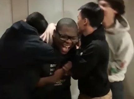 Lamar High School senior Micheal Brown is hugged by his friends after he is accepted to...