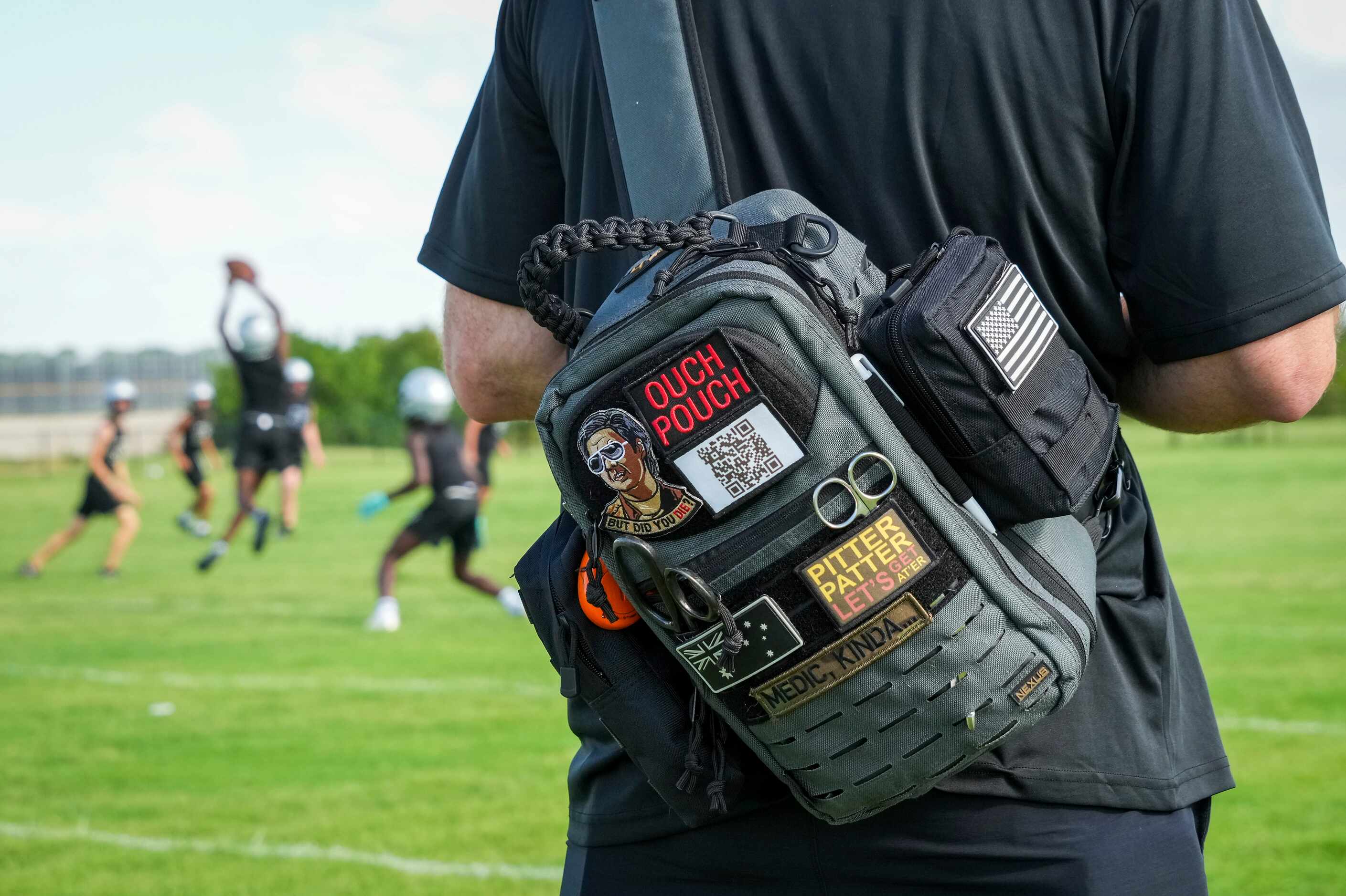 A trainer carries a first aid kit during the first day of football practice for Frisco...