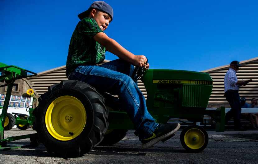Wyatt Luddeke, 9, of Cuero competes in the Kids' Pedal Tractor Pull at the State Fair of...