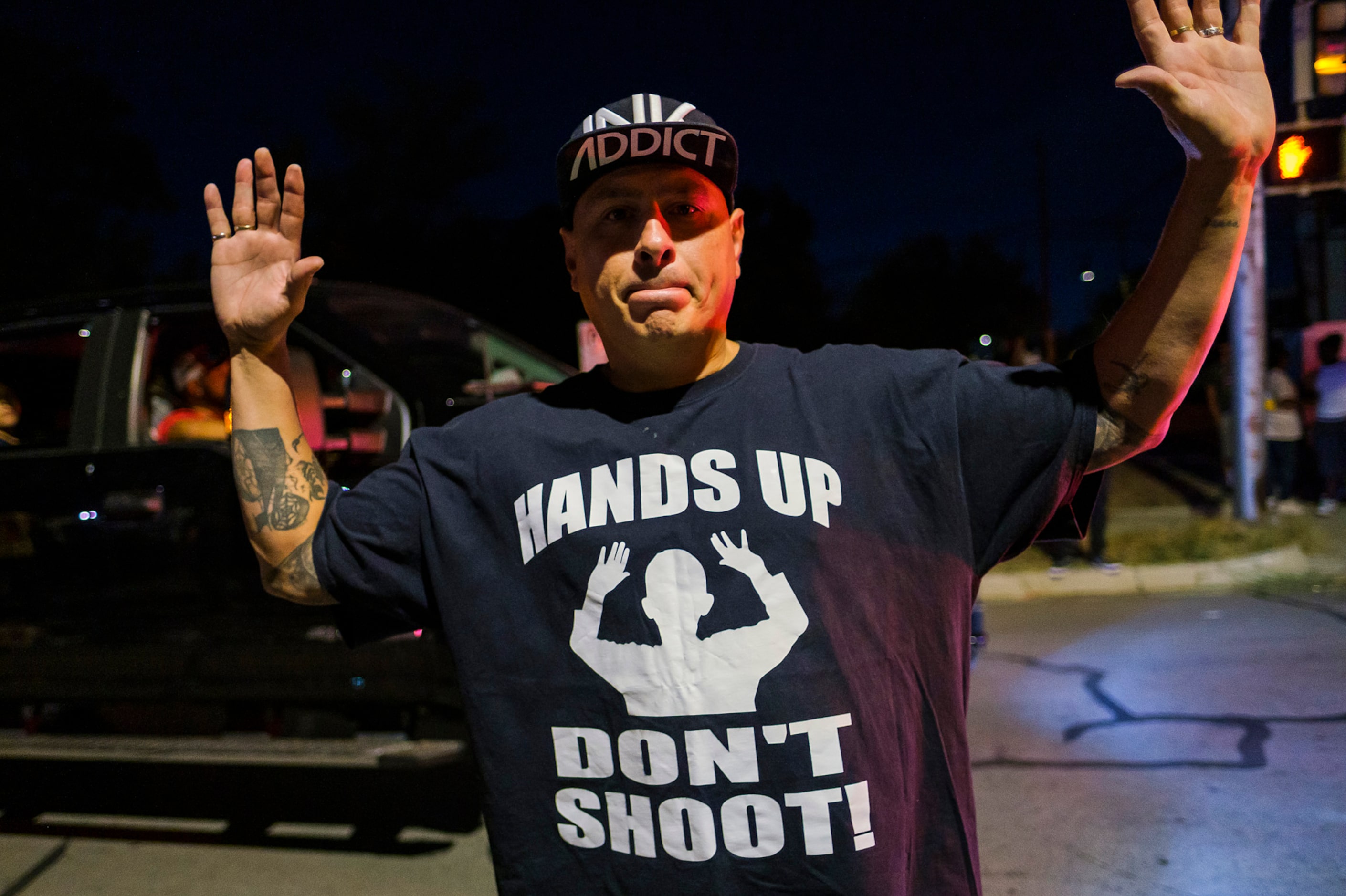 A man wears a shirt reading ÒHands Up DonÕt ShootÓ during a community vigil for Atatiana...