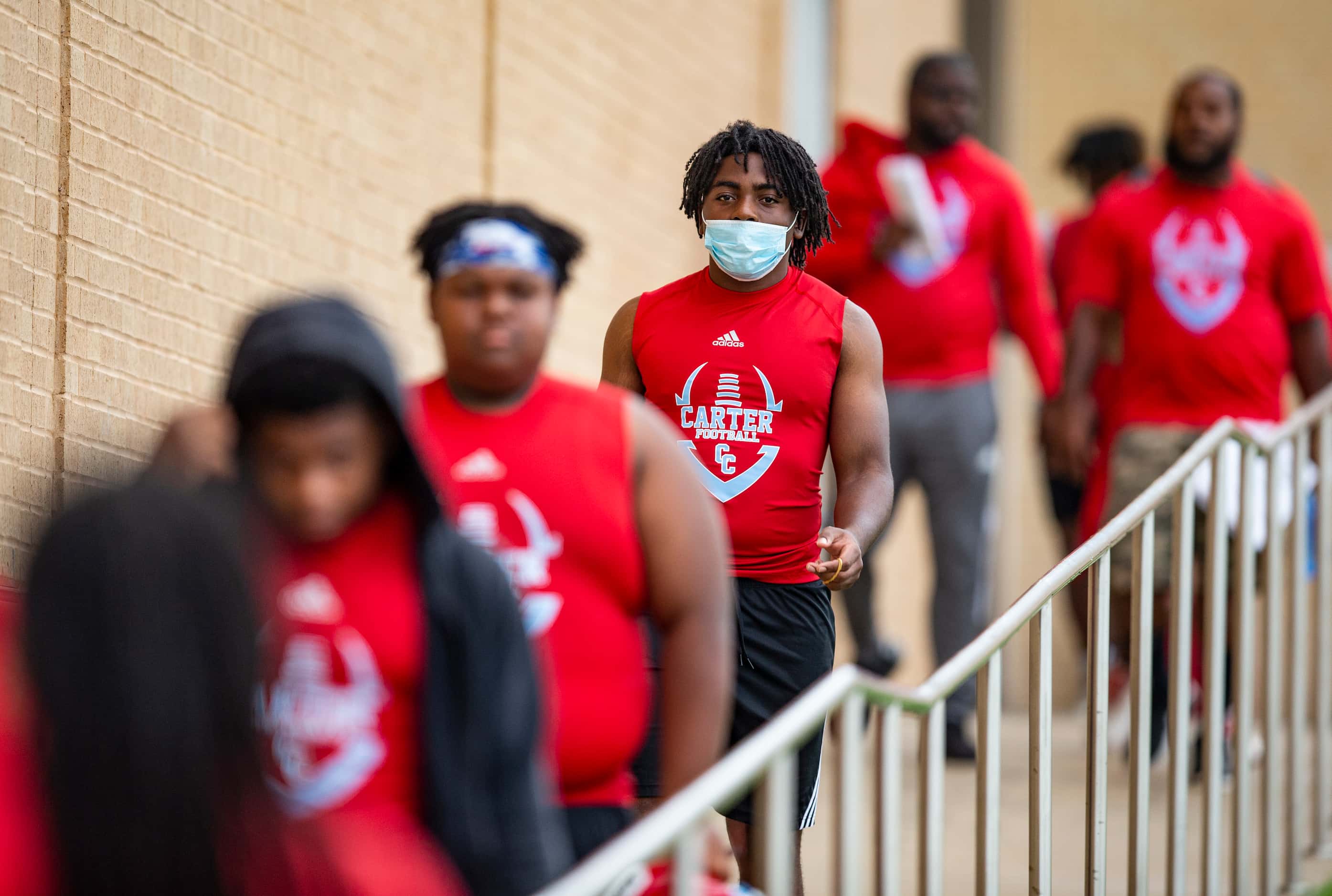 Carter High School football players head out to the practice field for the first day of...