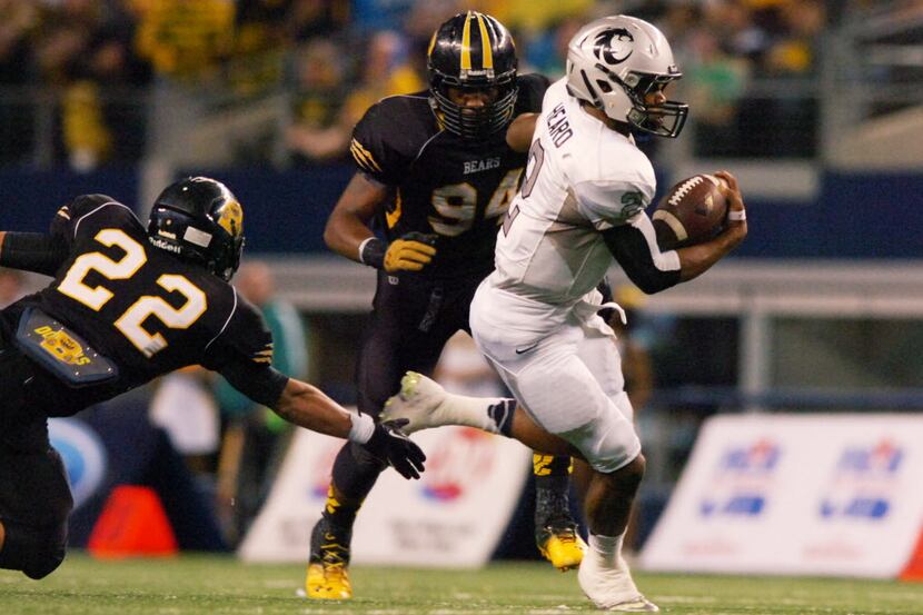 Guyer senior quarterback Jerrod Heard (2) rushes by a tackle attempt by Northside Brennan...