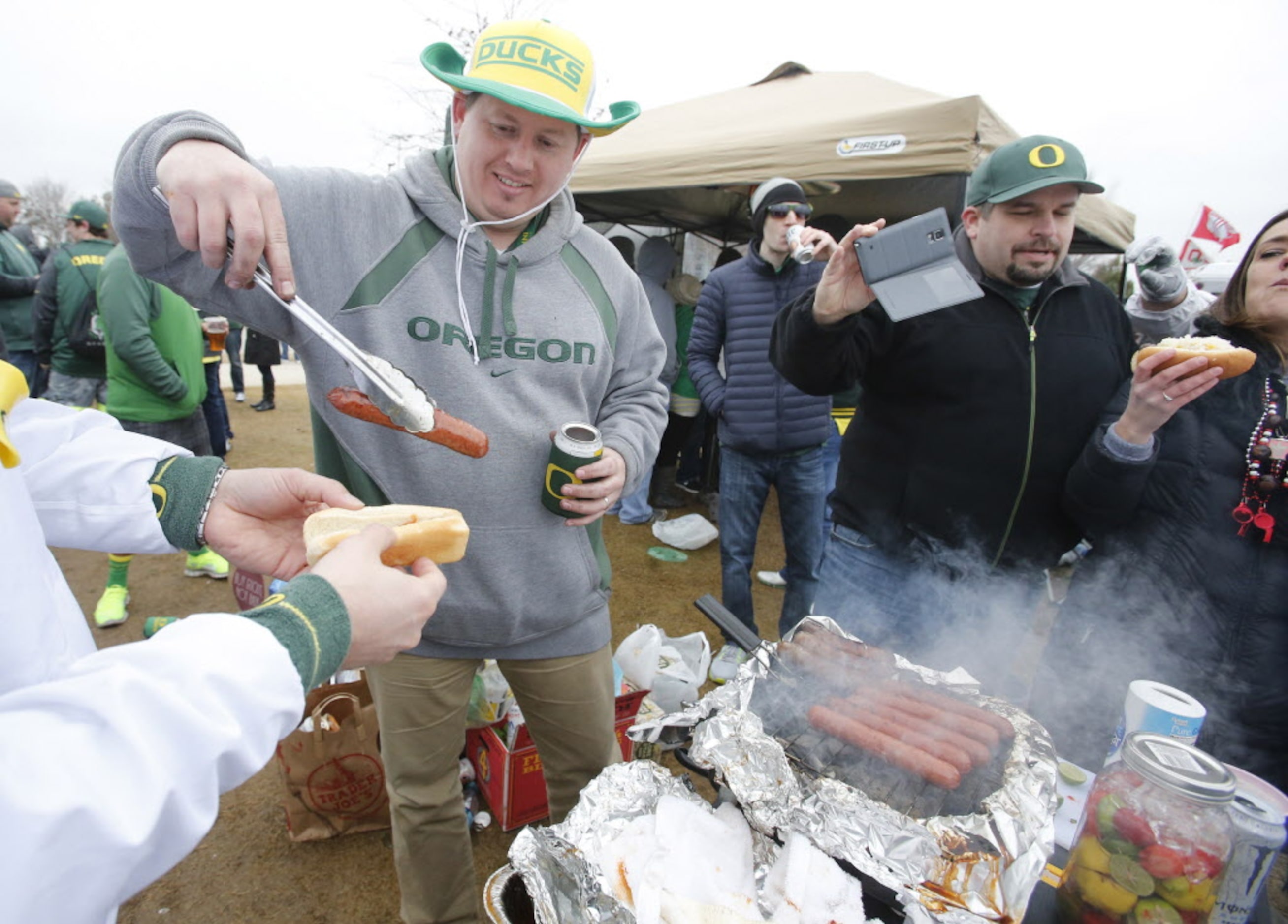 Gabriel Bailey from Washington DC mans the grill for his fellow Oregon fans as they tailgate...