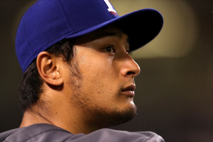 ANAHEIM, CA - MAY 02: Pitcher Yu Darvish #11 of the Texas Rangerslooks on from the dugout...