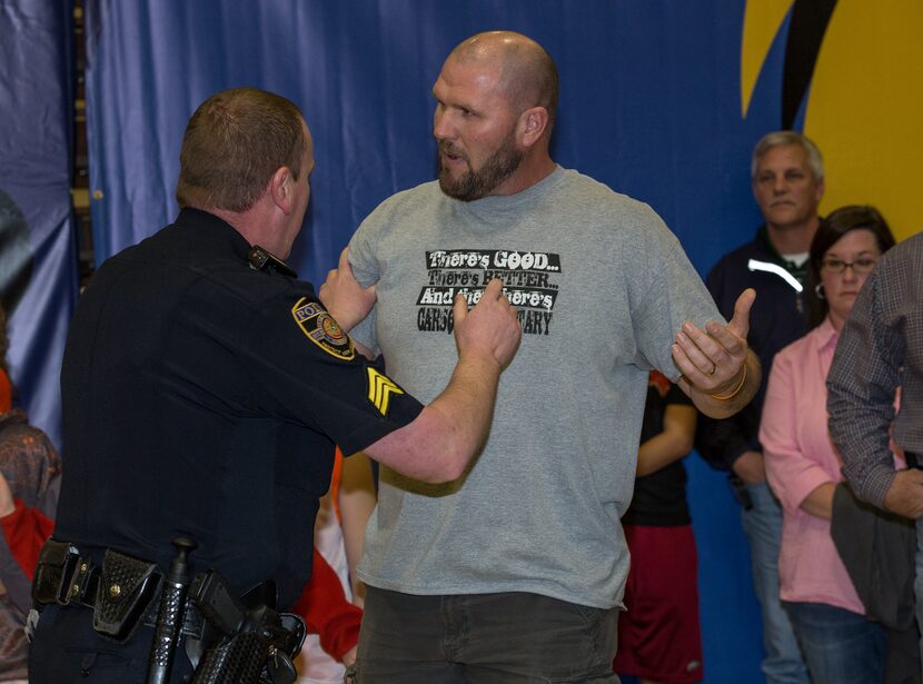 COMMERCE, TX - FEBRUARY 22: A police officer restrains a Celina fan that rushed the court...