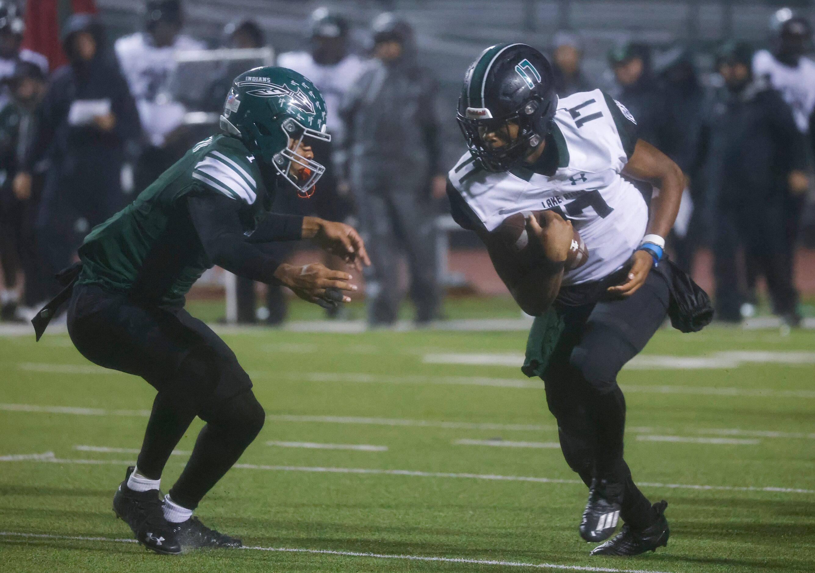 Mansfield Lake Ridge high’s Kennen Miller (17), right, runs past Waxahachie’s Keith Abney II...