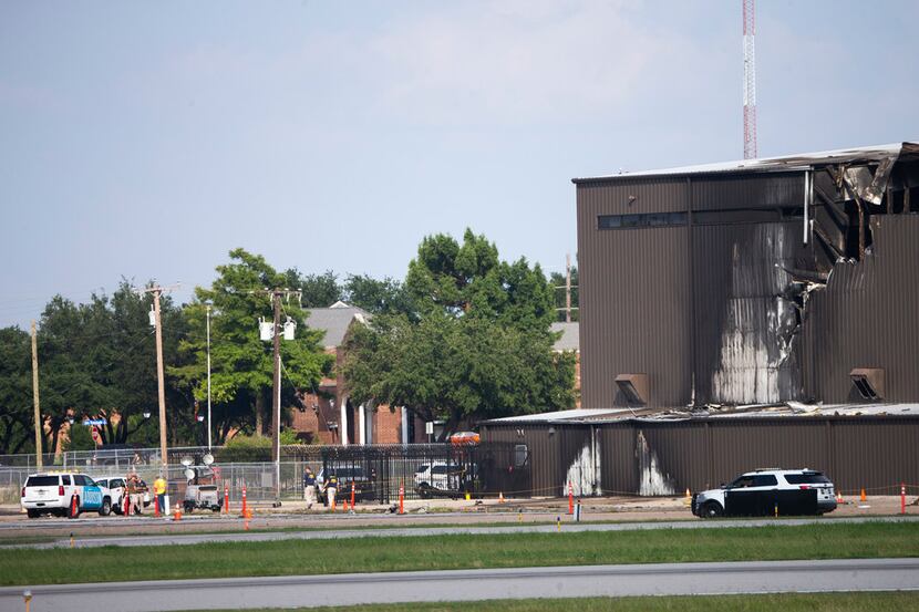 Damage is seen to a hangar after a twin-engine plane crashed into the building at Addison...