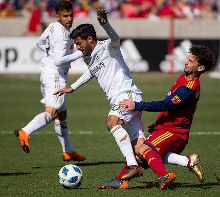 Real Salt Lake midfielder Kyle Beckerman, right, trips up Los Angeles FC forward Carlos Vela...