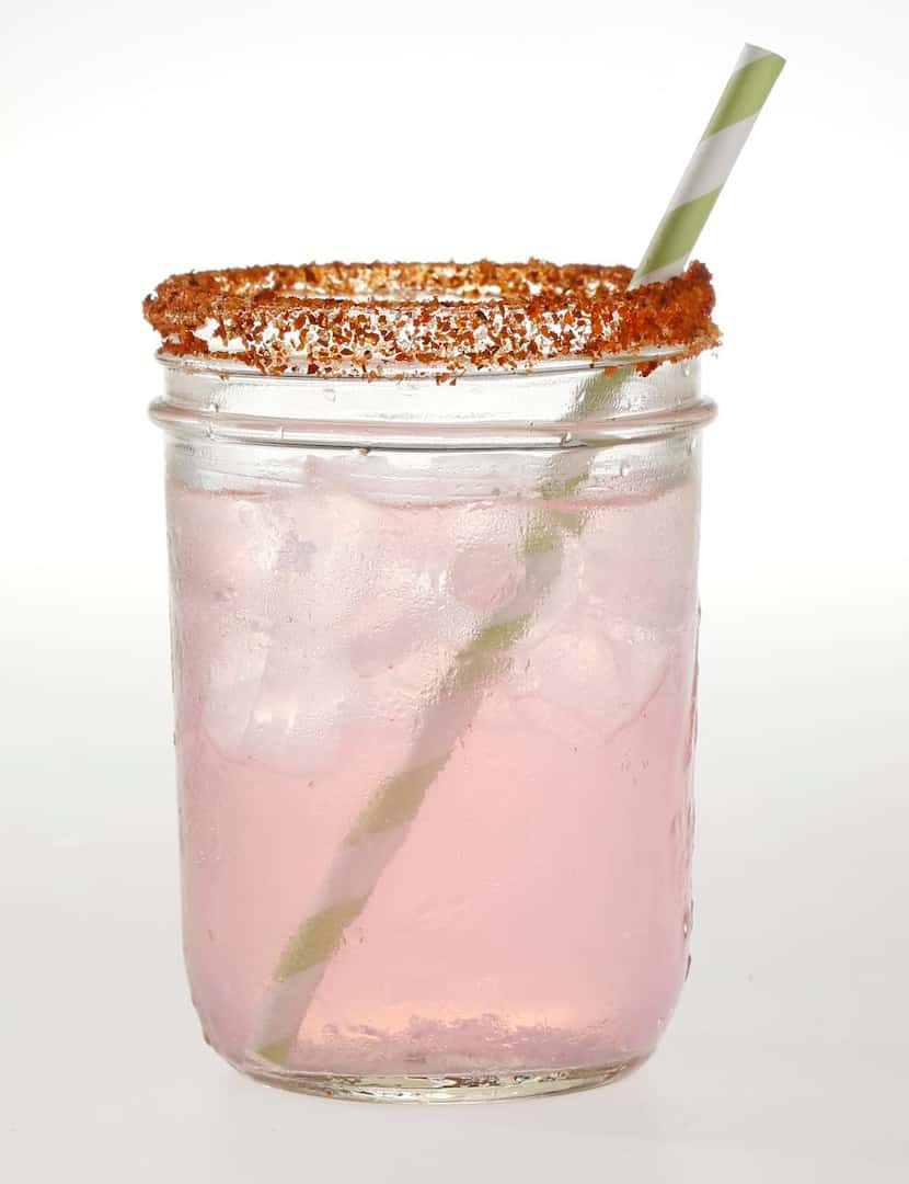 The Sassy Pink Angel from Palapas Seafood Bar features Topo Chico and a rim of Tajin seasoning.