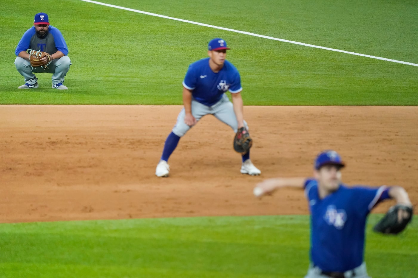 Texas Rangers infield coordinator Kenny Holmberg watches from the field as Jason Bahr...