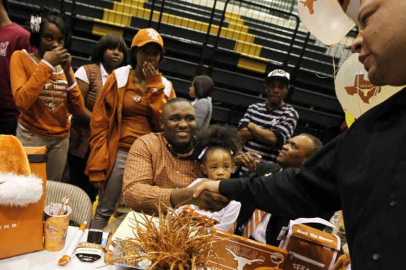Curtis Riser (center) shakes hands with a fan during a National Signing Day event Wednesday,...
