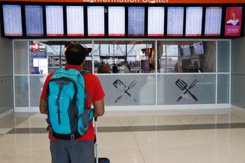 Vitesh Bhakta of Dallas, checks the flight information board in the newly remolded Terminal...