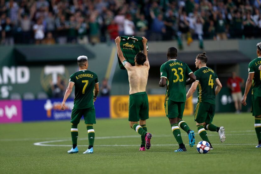 Portland Timbers' Diego Valeri (8) removes his shirt during the first half of an MLS soccer...