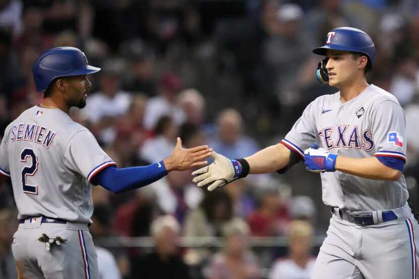 Texas Rangers’ Corey Seager, right, is congratulated by Marcus Semien (2) after hitting a...