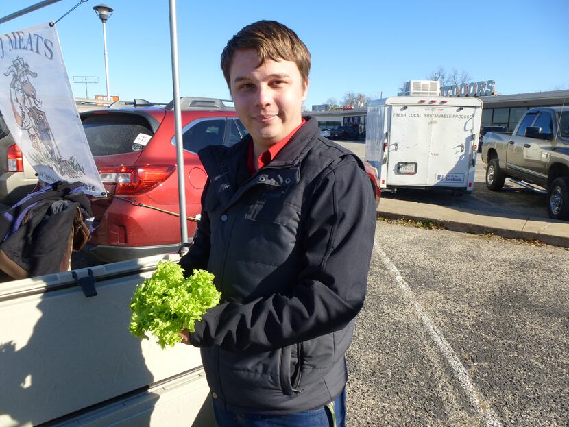 Colton Fambro holds one of his green incised lettuce heads at Cowtown Farmers Market. His...