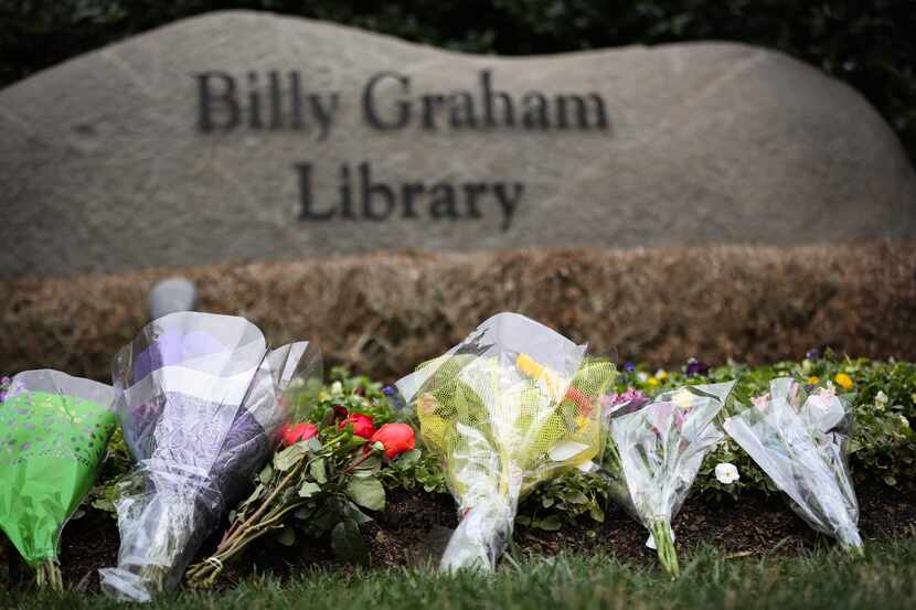 Flowers were left by mourners at the Billy Graham Library in Charlotte, N.C., hours after...