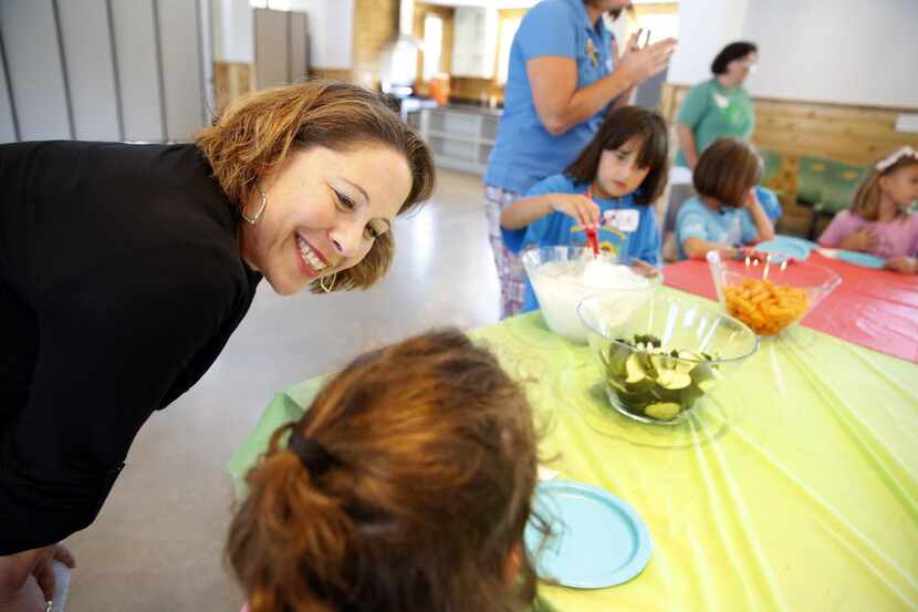 Girl Scouts of Northeast Texas CEO Jennifer Bartkowski (left) listens to young girls explain...