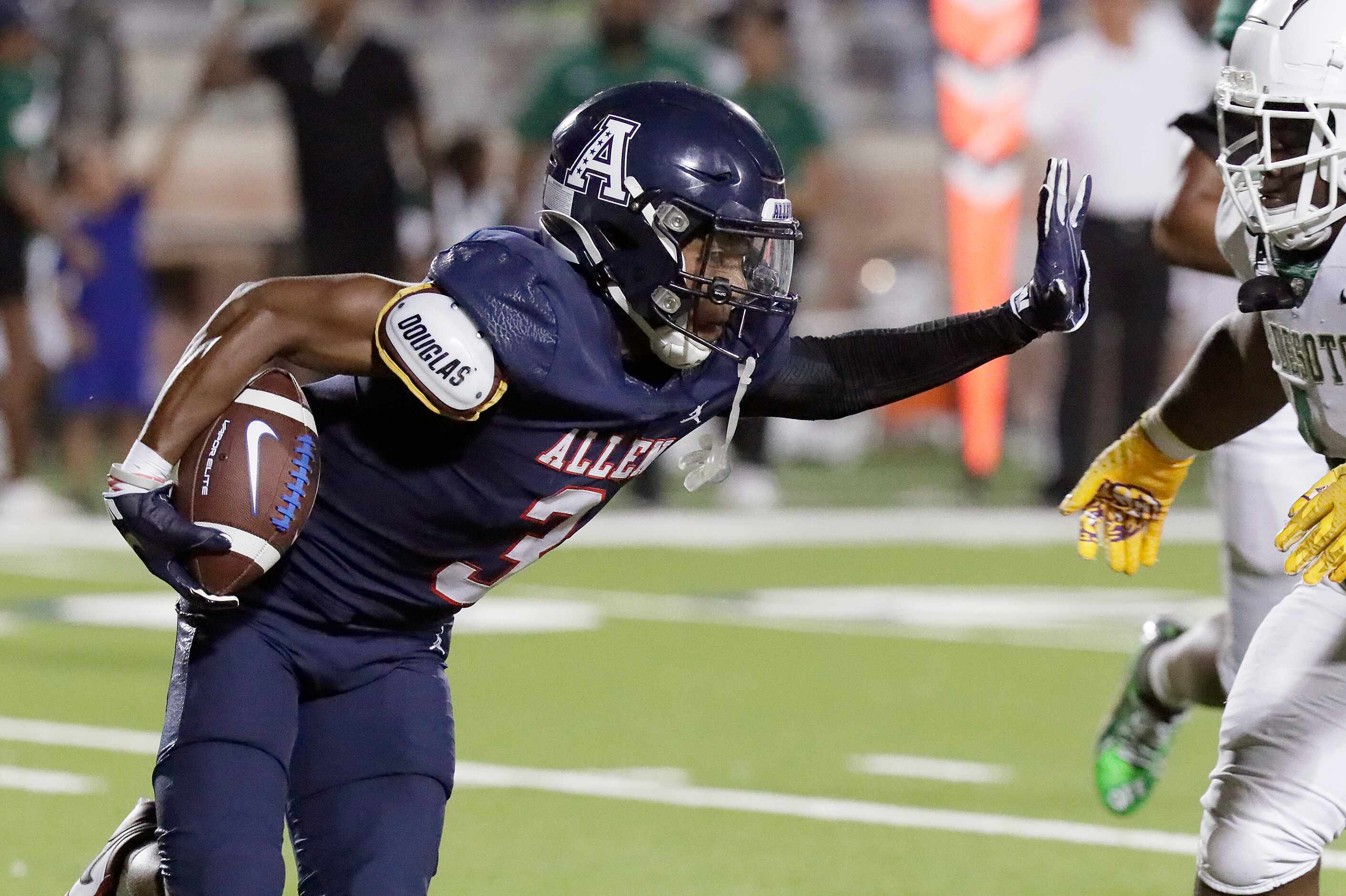 Allen High School wide receiver Caleb Smith (3) gives a stiff arm during the first half as...