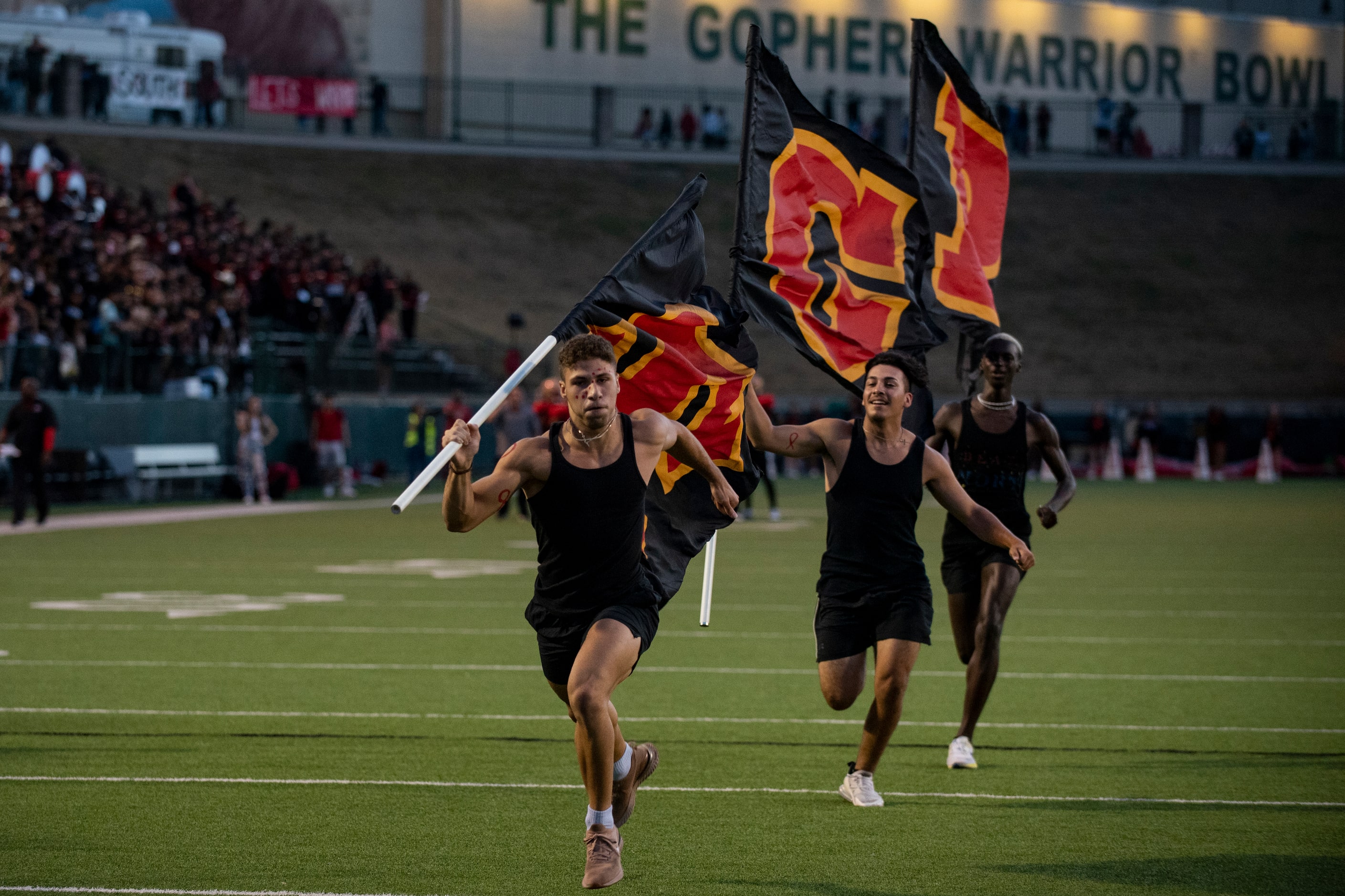 From left, flag runners Kian Erakat, 17, Josiah Darrough, 17, and Kevon Benson, 18, sprint...