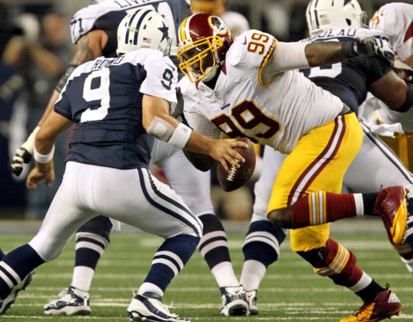 Dallas quarterback Tony Romo (9) comes eye to eye with Washington defensive lineman Jarvis...