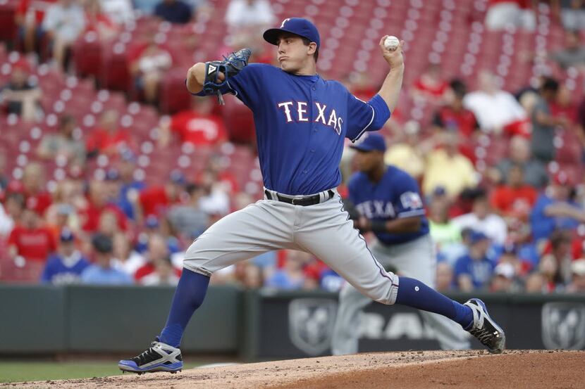 Texas Rangers starting pitcher Derek Holland throws during the first inning of a baseball...