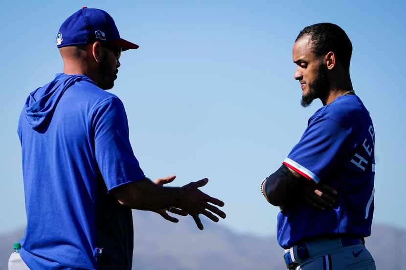 Texas Rangers pitcher Jonathan Hernandez talks with manager Chris Woodward after throwing a...
