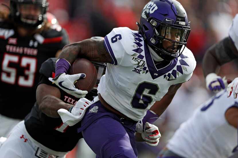 TCU's Darius Anderson (6) breaks a tackle while running with the ball during the first half...