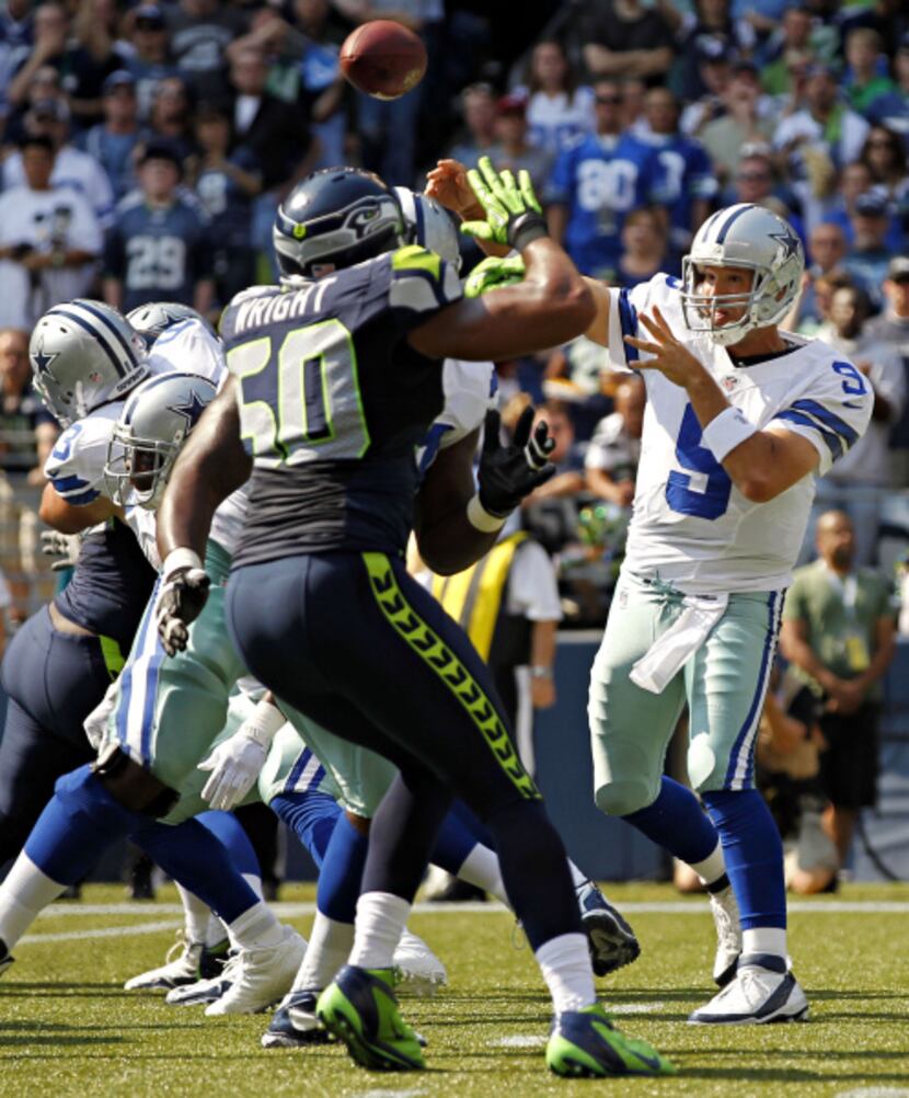 Dallas Cowboys quarterback Tony Romo (9) passes under pressure from Seattle Seahawks outside...