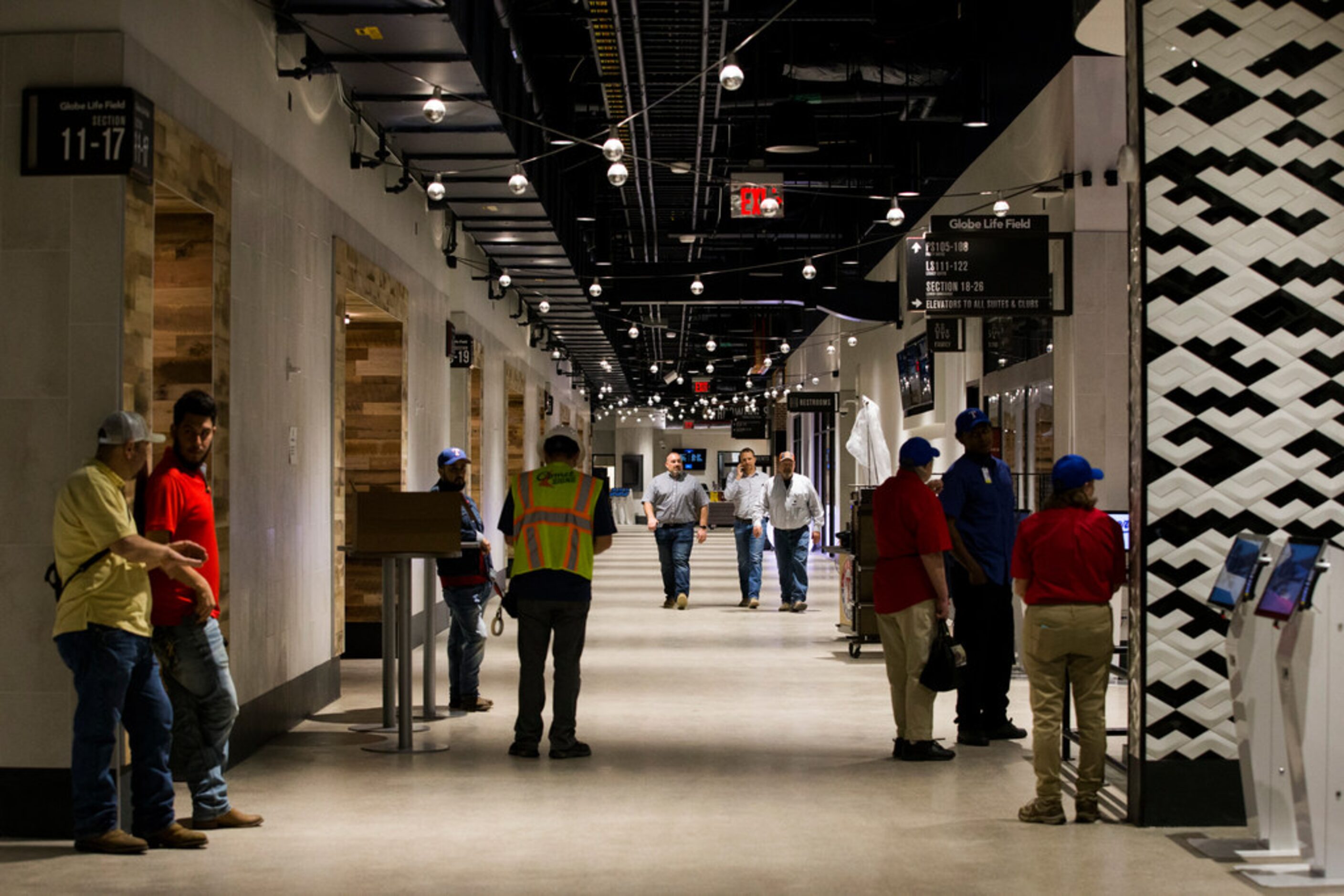 Workers walk through the lower concourse during an open house for the Texas Rangers' new...