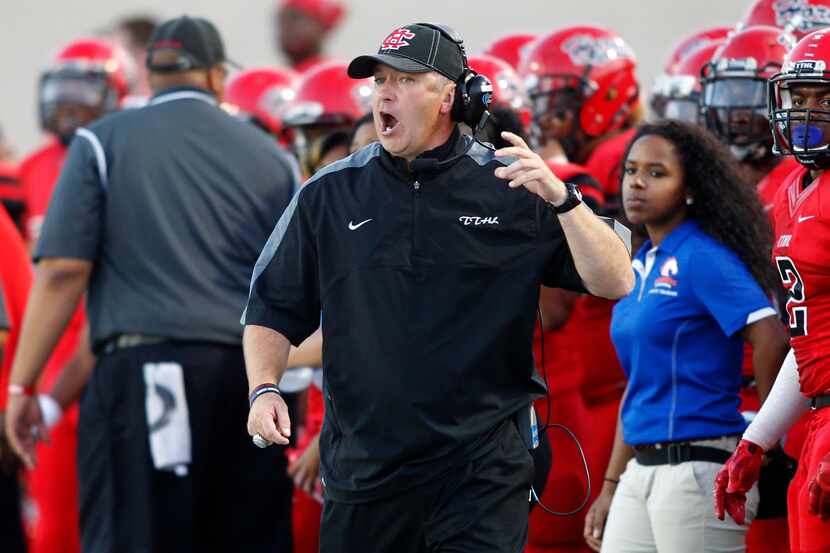 Cedar Hill head coach Joey McGuire yells towards the field in the first half of the football...